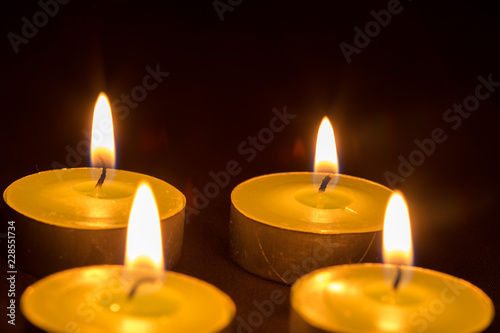 Group of burning candles on black background © donikz