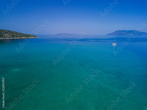 Aerial drone bird's eye view photo of tourists snorkeling above old Sunken City of Epidauros, Greece