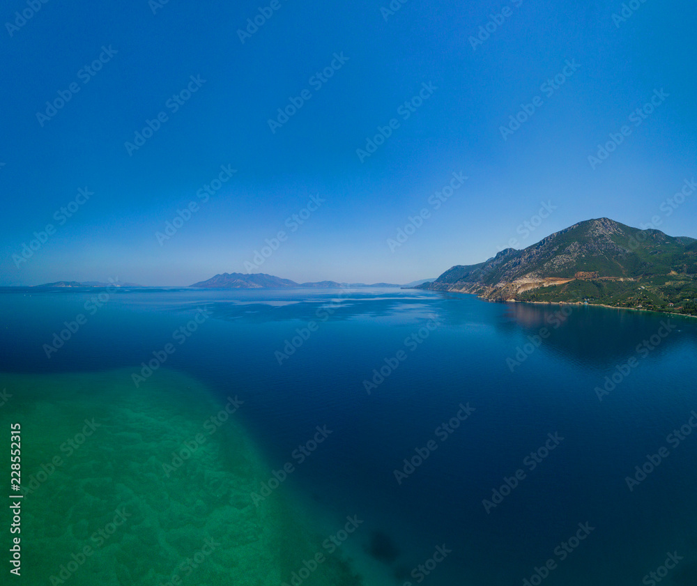 Aerial drone bird's eye view photo of tourists snorkeling above old Sunken City of Epidauros, Greece