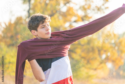 Fotografija young male teenage hipster put on a sweatshirt sweater outdoors walking in natur