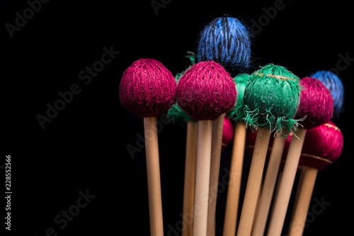 Foto Colorful percussion mallets on a black background