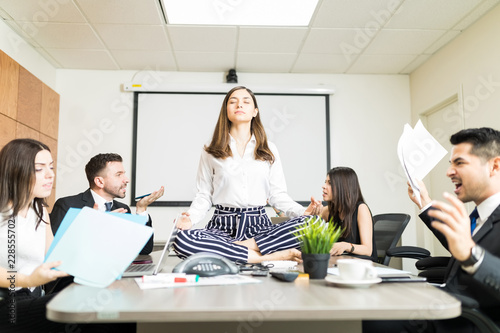 Foto Stressed Businesswoman Meditating and Trying to Keep Calm In Meeting Room