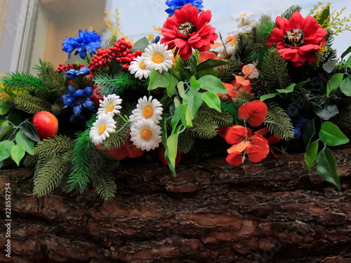 A bouquet of different flowers in a wooden log