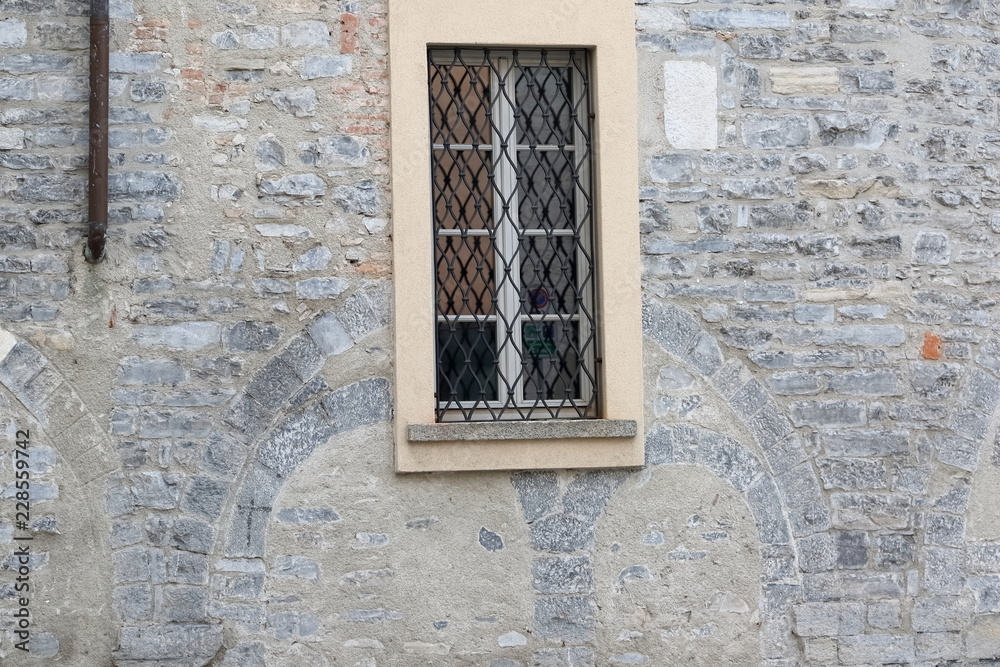 finestra in legno con sbarre ferro battuto e mura antiche