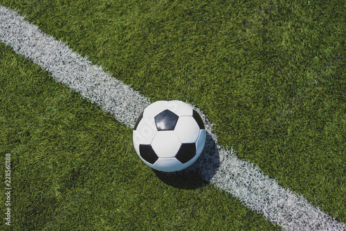 Soccer ball on green grass over the white line