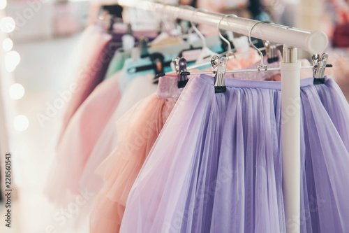 Clothing for a little girl on a clothes rack in a wardrobe. Fashion show. photo