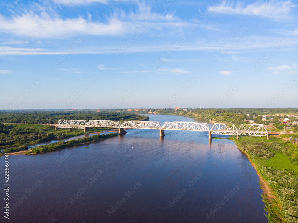 a panorama from a height, a typical small city in central Russia and the river Vyatka with railroad bridge