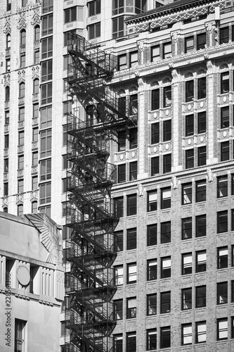 Black and white picture of an old building with fire escape, New York City, USA.