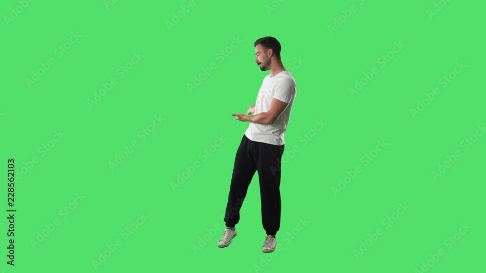 Young sport casual handsome man inviting and welcoming hand gesture smiling. Full body isolated on green screen background. Young sport casual handsome man inviting and welcoming hand gesture smiling. Full body isolated on green screen background.