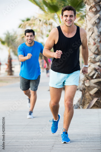 Portrait of adult man who is jogging with friend