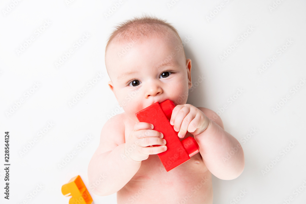 Baby boy plays with toy blocks over white background Baby boy plays with toy blocks over white background