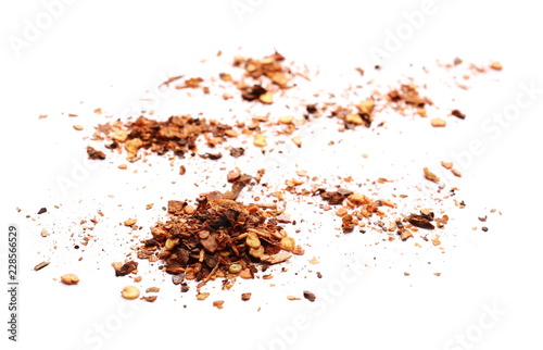 pile dry crushed red pepper, dried chili flakes and seeds isolated on white background