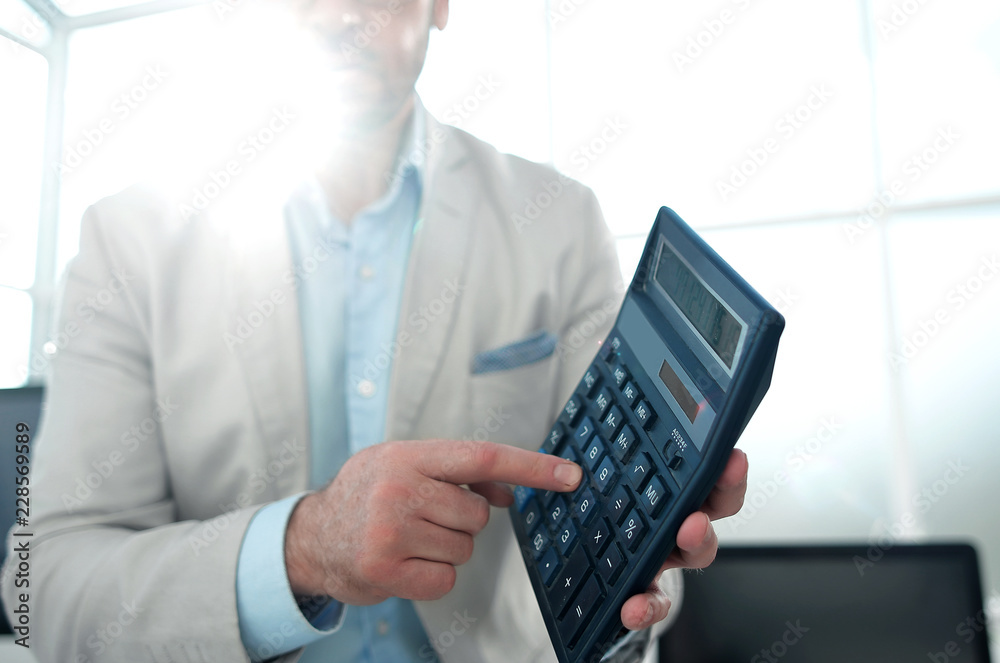 confident businessman pointing to calculator confident businessman pointing to calculator