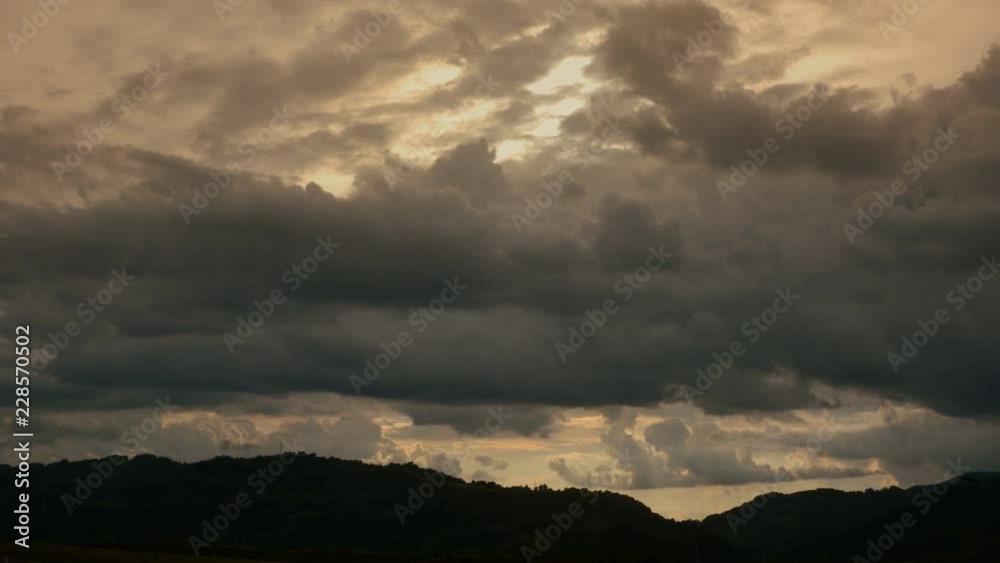 Dark clouds passing by over hills Dark clouds passing by over hills