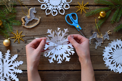 Making paper snowflakes with your own hands. Children's DIY. Merry Christmas and New Year concept.