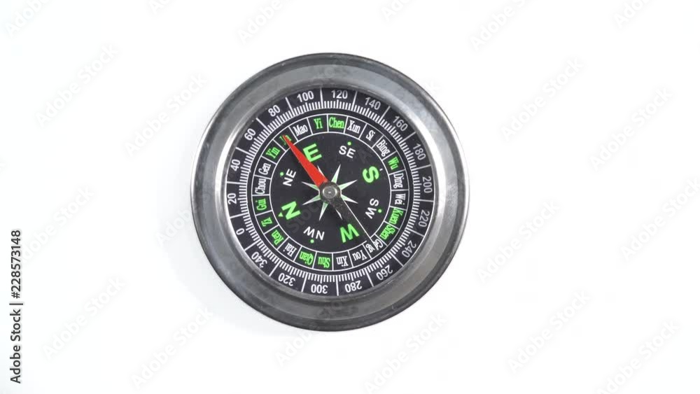 Black compass rotating on white background. Travel, tourism and exploration. Top down view Black compass rotating on white background. Travel, tourism and exploration. Top down view