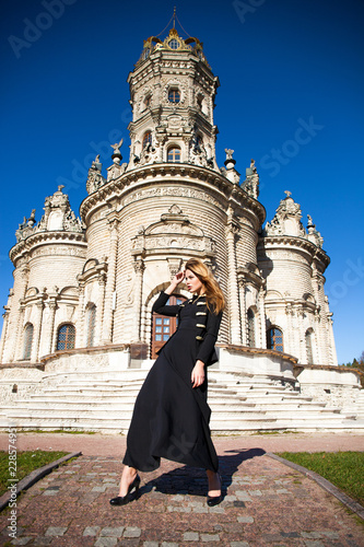 Young woman in black dress on the background of the church