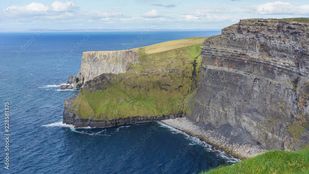 view of the Cliffs of Moher  looming over the Atlantic Ocean in County Clare, Ireland