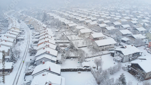 Bild auf Leinwand AERIAL: Flying above the white snowy backyards on a spectacular winter day