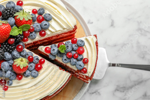 Delicious homemade red velvet cake with fresh berries on table, top view