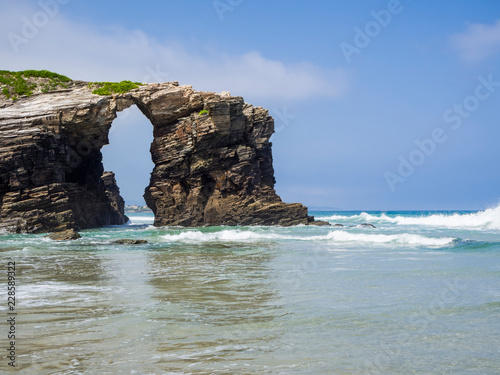 Entorno natural de La Playa de Las Catedrales con arcos de piedra sobre la arena, en Lugo, Galicia, vacaciones en España, verano de 2018