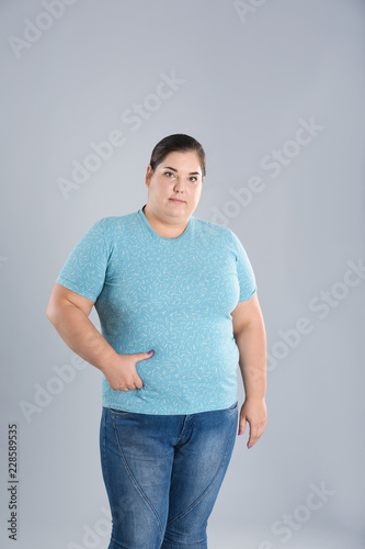 Overweight woman touching belly fat before weight loss on color background