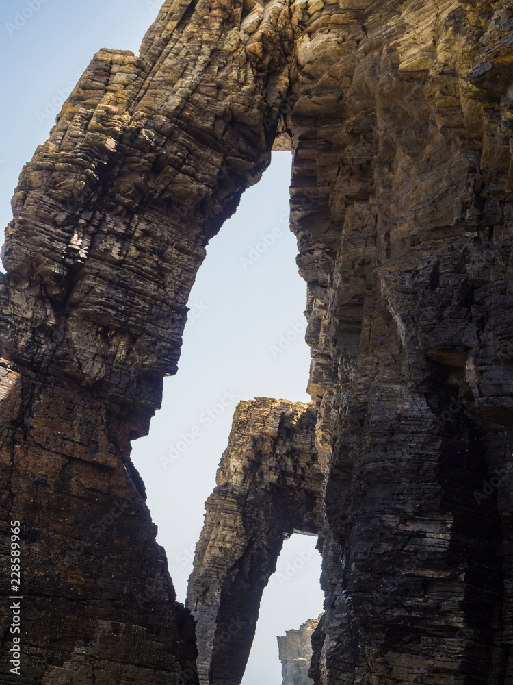 Entorno natural de La Playa de Las Catedrales con arcos de piedra sobre la arena, en Lugo, Galicia, vacaciones en España, verano de 2018