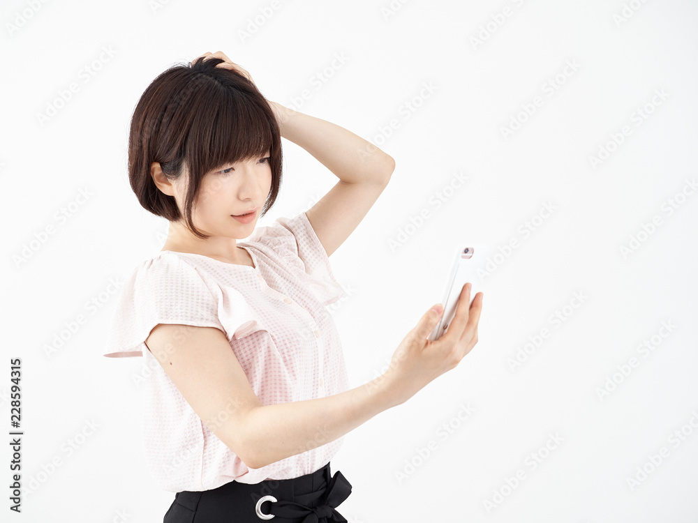 参った顔でスマホを操作する女性