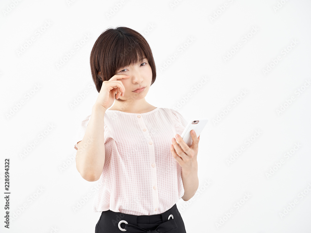 泣き顔でスマホを操作する女性 Stock Photo Adobe Stock