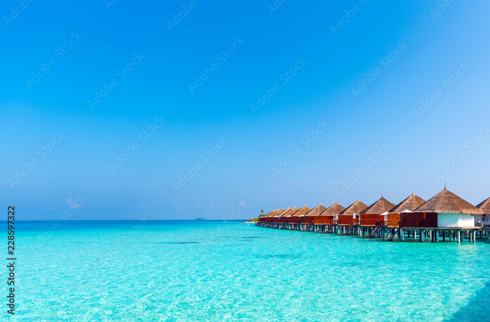 Water villas in a row by the seashore, Maldives. Copy space for text.