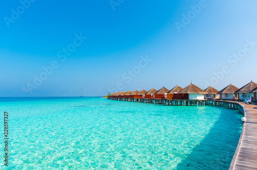 Fototapeta Naklejka Na Ścianę i Meble -  Water villas in a row by the seashore, Maldives. Copy space for text.
