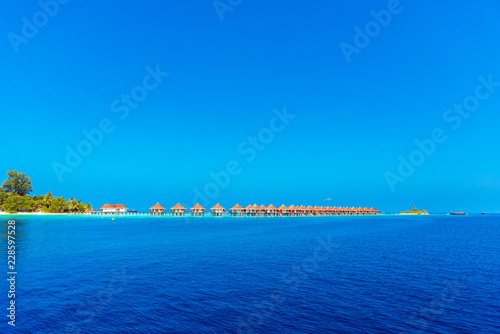 Fototapeta Naklejka Na Ścianę i Meble -  Water bungalow in a raw with turquoise ocean, Maldives. Copy space for text.