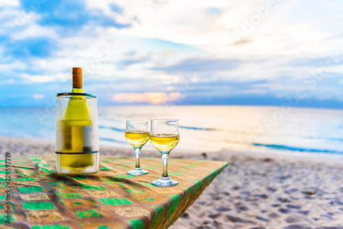 A bottle of wine and two glasses against the sea in Moalboal, Cebu, Philippines. With selective focus. photo