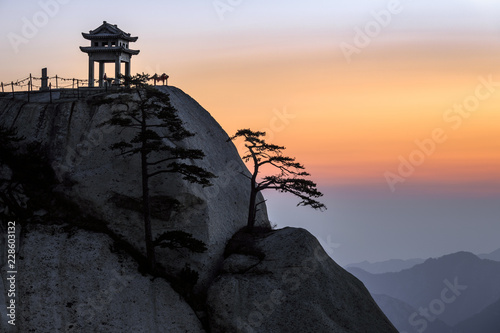 Huashan Sunrise, Mount Hua - Huayin, near Xi'an in Shaanxi Province China. Chess Playing Pavilion, Pagoda at the top of a Cliff with Steep Vertical Drop-off, Famous yellow granite mountains of China. photo