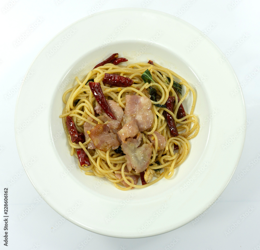 Spaghetti with Dried Chili And Crispy Bacon yellow line in a dish on white background,Top view,Close up..