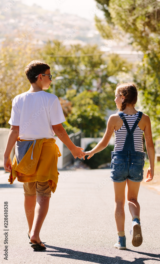 Boy and girl in love walking on street holding hands Boy and girl in love walking on street holding hands