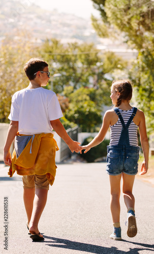 Boy and girl in love walking on street holding hands