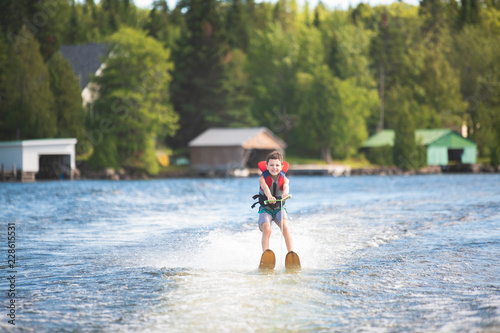 Child learning to water skiing on a lake