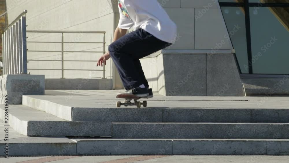 Unrecognizable Skateboarder does ollie on stairs on the street, slowmotion Unrecognizable Skateboarder does ollie on stairs on the street, slowmotion