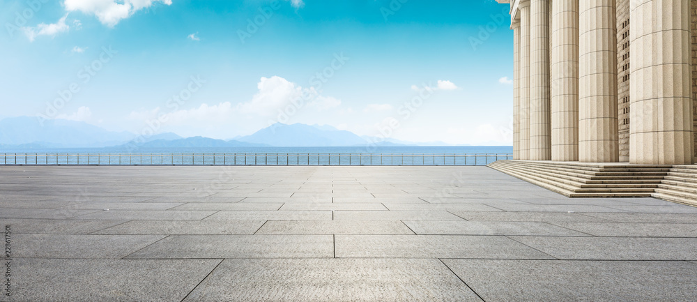 Empty square floor and modern architecture with mountain natural scenery Empty square floor and modern architecture with mountain natural scenery