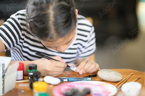 Fototapeta Naklejka Na Ścianę i Meble -  Cropped shot of young girl artist painting with water colour on rock.