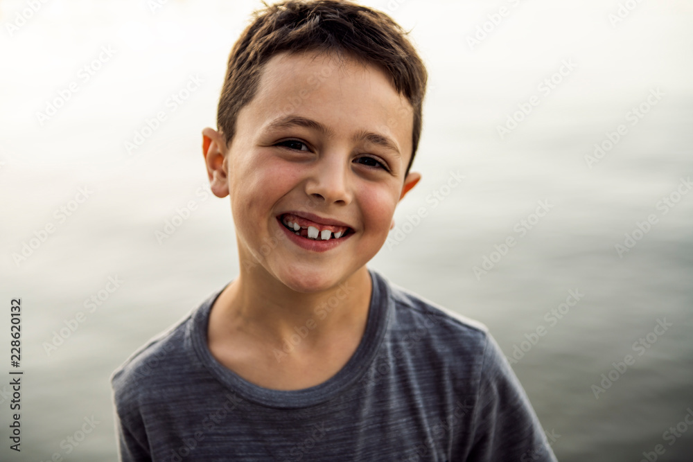 Outdoor portrait of adorable child boy next to lake at the sunset Outdoor portrait of adorable child boy next to lake at the sunset