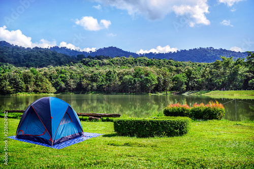 Camping in Green Grass With Blue Sky Background