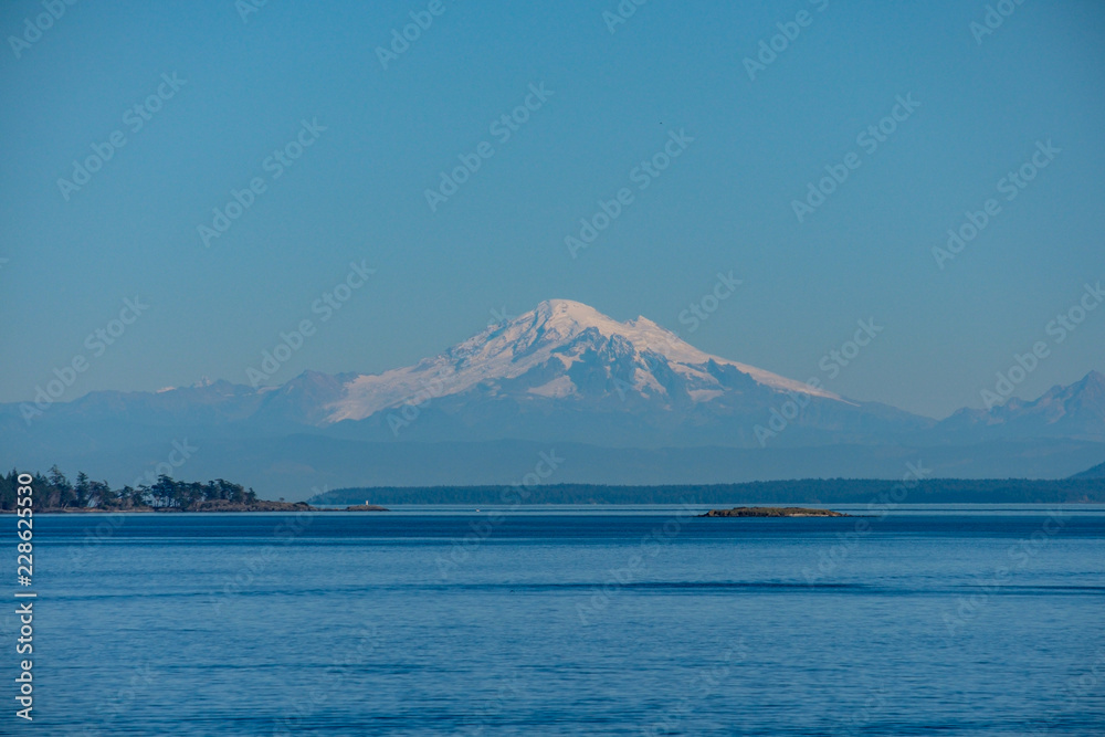 view of mount baker over the sea on a sunny day