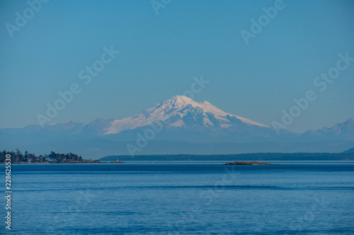 view of mount baker over the sea on a sunny day