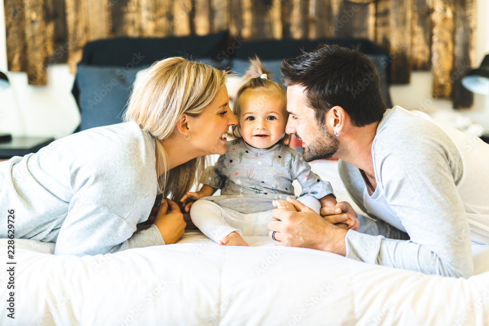 Fototapeta premium Family on bed with his baby on the morning