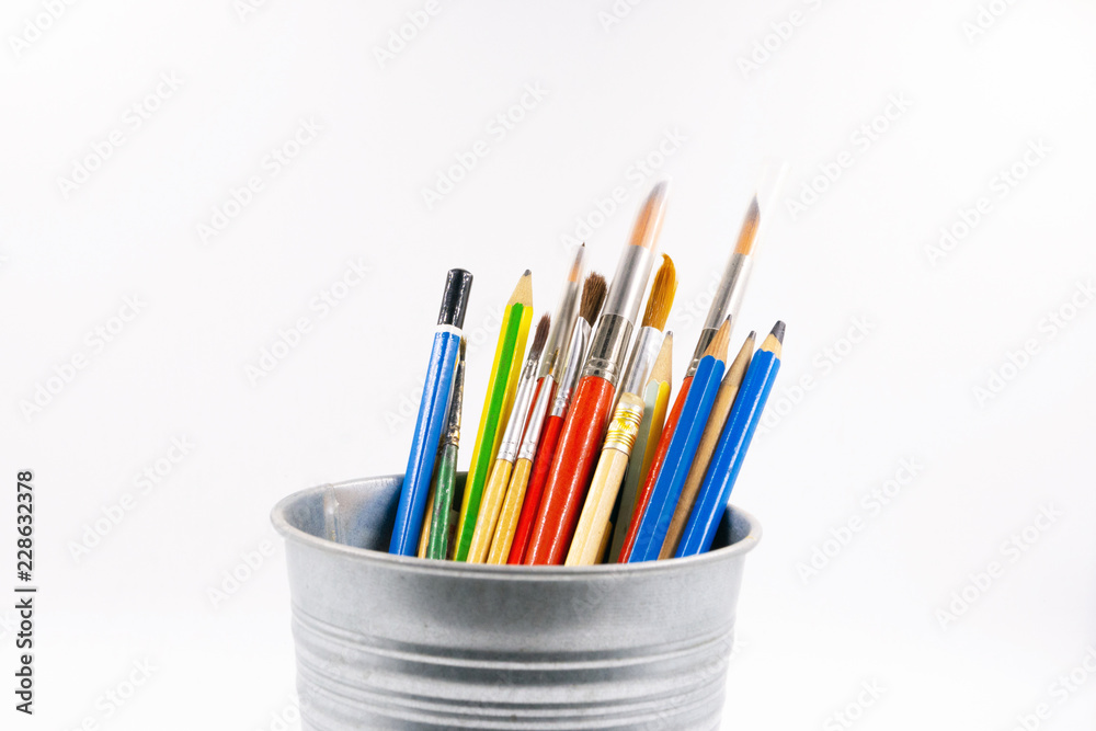 Fototapeta premium colored pencils and brushes to draw in jar, background