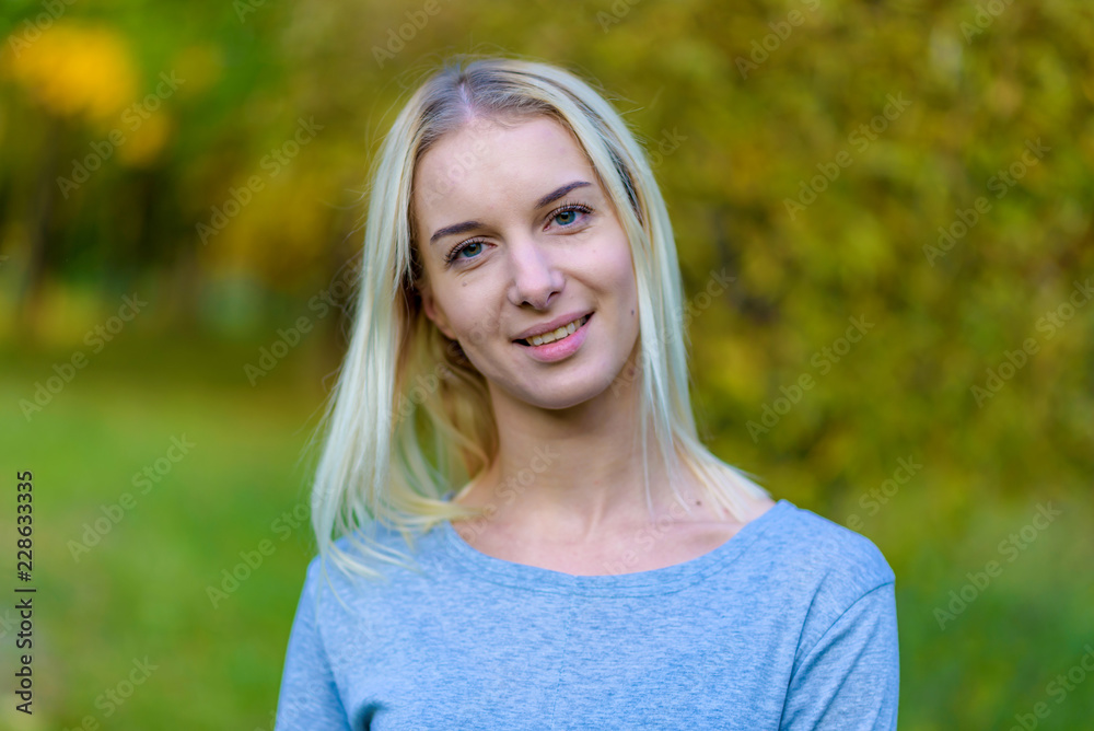 Photo portrait of a beautiful blonde girl in the park on the street in the sunset sun evening.