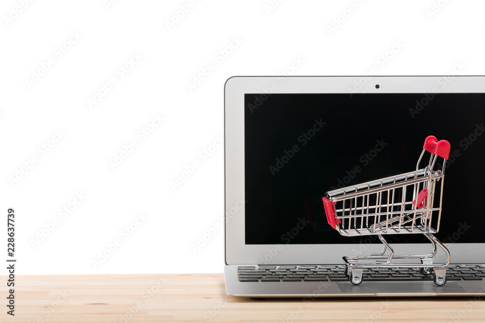 Red shopping cart on a laptop isolated on white background. Online internet shopping concept. Free space for your text