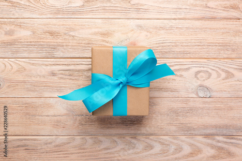 Vintage gift box with blue ribbon on wooden background. top view